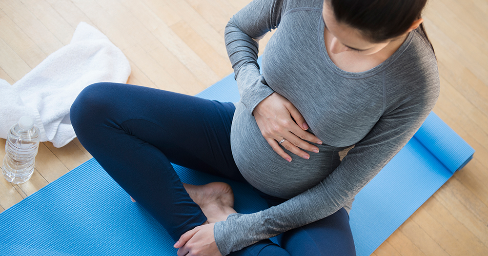 Pregnant Caucasian woman practicing yoga